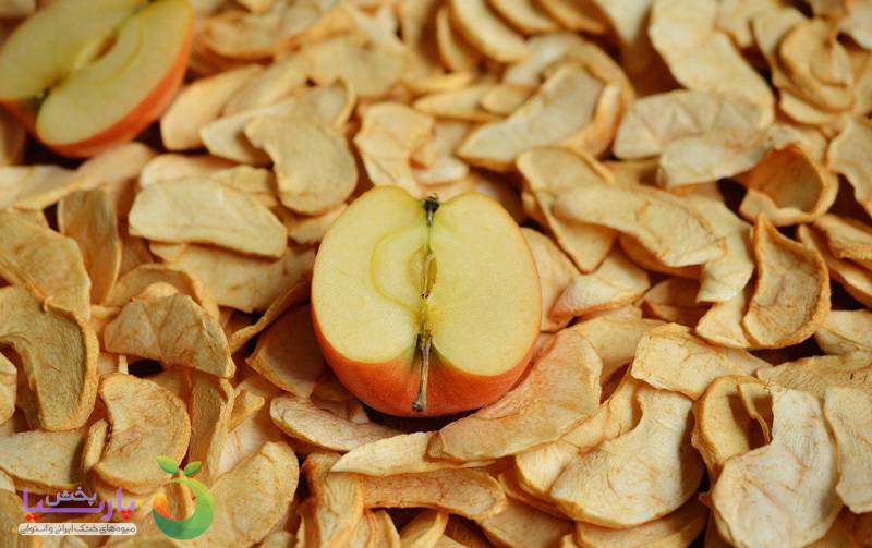 نصف سیب تازه بر روی تکه های سیب خشک شده